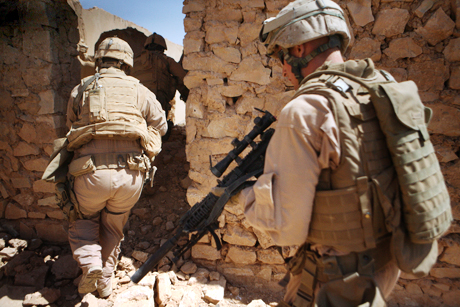 The Norman Hatch Combat Photography Award Honorable Mention - Cpl. Ryan Tomlinson: Marines with Charlie Company, 2nd Light Armored Reconnaissance Battalion, Regimental Combat Team 5 ensure the area is clear of threats during a cache search in western Anbar province May 1. The Marines with Charlie Company have found several caches around the area, including one with more than six 120 mm rounds the day before.