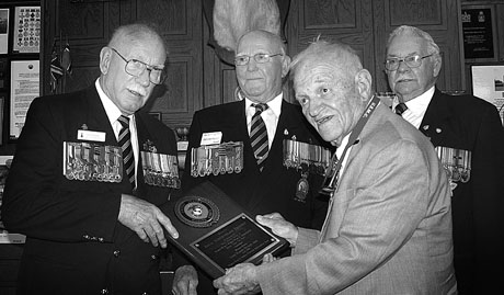 Former U.S. Marine combat correspondent Cyril O’Brien (3rd from left) presents a plaque honoring the Royal Newfoundland Regiment in ceremonies at Grand Falls , Newfoundland , on June 17. The plaque was presented on behalf of the U.S. Third Marine Division Association to regimental veterans (from left) Colonel Jim Molloy, Gunner 