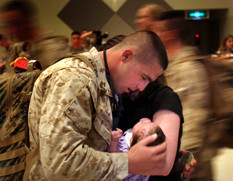 News Photography 2nd Place - LCpl. Bobby J. Yarbrough: HM 3 Maykel Suarezapecheche sees his newborn daughter for the first time after a seven-month deployment to Iraq. Suarezapecheche served as a line corpsman with Motor Transportation Company, Combat Logistics Battalion-4 during his deployment.
