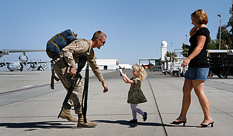News Photography Honorable Mention - LCpl. Pete Zrioka:  Cpl. Dustin Sholl, a Marine Attack Squadron 311 plane captain, is greeted by his daughter Julianna and his wife Kristen Friday on the flight line here after returning from a deployment to Iraq. Sholl was one of approximately 170 Marines from VMA-311 and Marine Aviation Logistics Squadron 13 who recently returned from the six-month deployment.