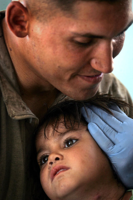 Open Photography Honorable Mention - Sgt. Ray Lewis:  First Lt. Eric M. Lukas comforts three-year-old Afghan girl Miriam during a Marine-led health cooperative called Medical Capabilities (MEDCAP) here. Lukas and other Marines, sailors and an airman with Task Force 2d Battalion, 7th Marine Regiment, 1st Marine Regiment, Combined Joint Task Force Phoenix Marines, were instrumental in removing an infected boil from the girl’s neck.