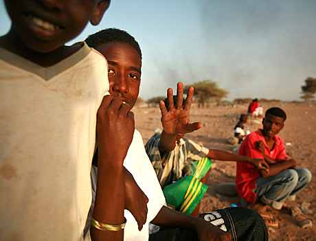 1st Place Photojournalism by Sgt. Alex Kleinsmith: Children from Camel Douda sit on the sidelines while watching Marines from 3rd Low Altitude Air Defense Battalion take on local Djiboutians during a friendly soccer match.